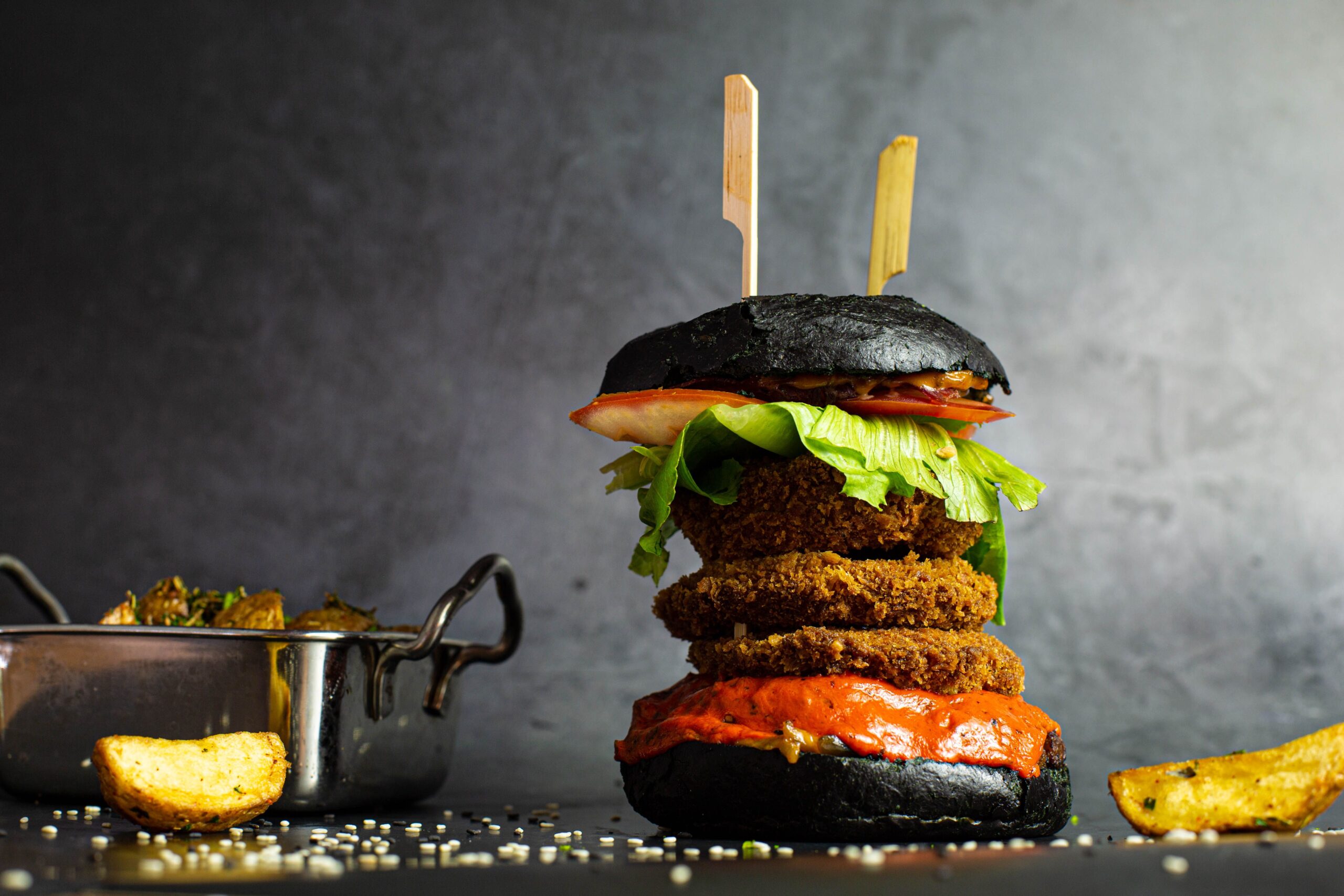 closeup-shot-of-a-tall-burger-with-black-buns-and-2023-11-27-05-07-41-utc-min